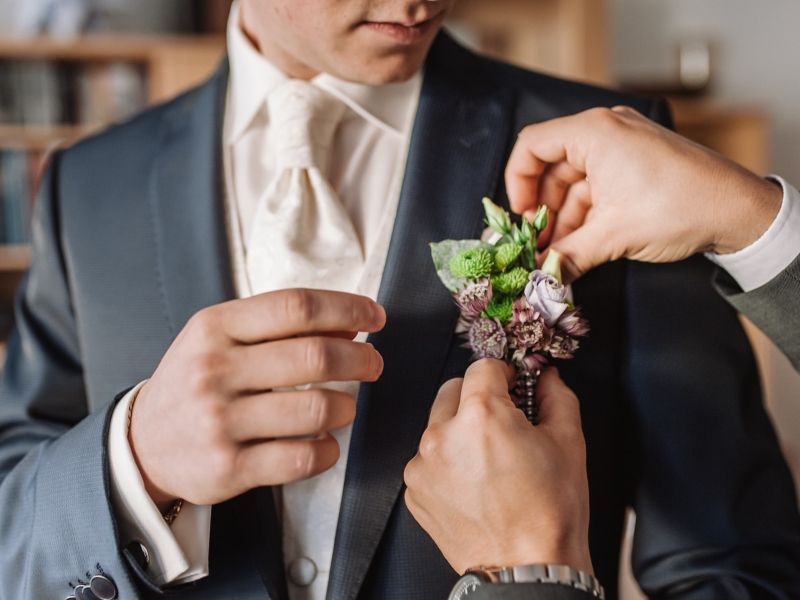 Groom getting a flower in the front pocket